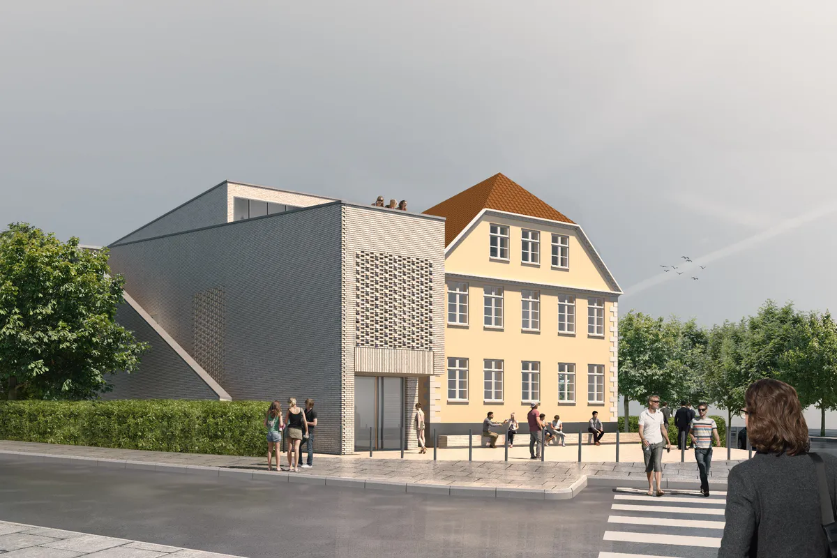 Deutsches Museum Nordschleswig — moderne grå murstensbygning med mønsterfacade forbundet til et klassisk gult palæ med rødt tag, omgivet af træer og grønne hække under en sommerhimmel, med gæster og forbipasserende på fortovet