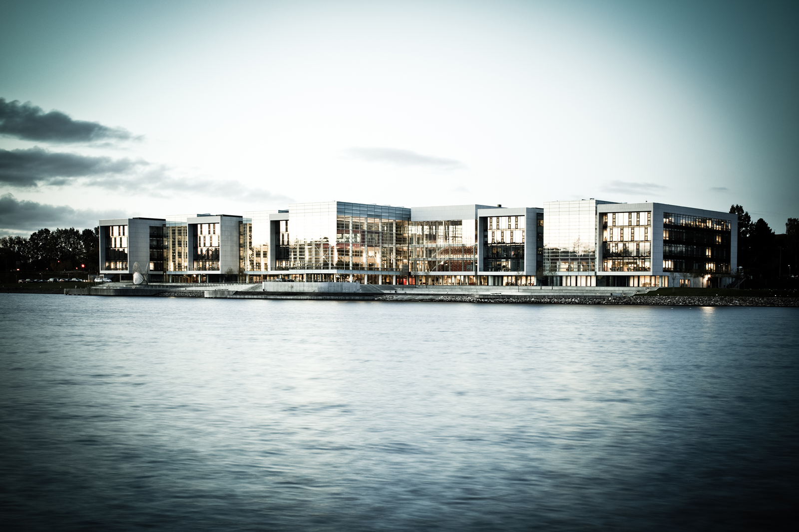 Alsion — moderne glas- og betonbygning ved vandet i Sønderborg, spejlet i Als Sund
